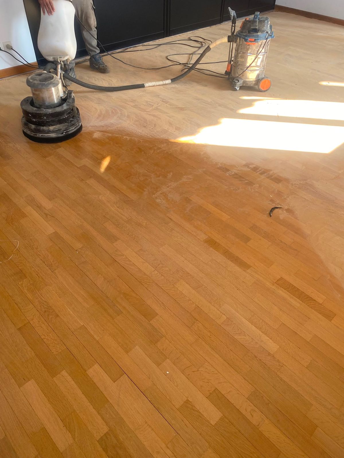Ponçage du parquet, contraste entre la zone poncée et le vernis d'origine à Paris 15e