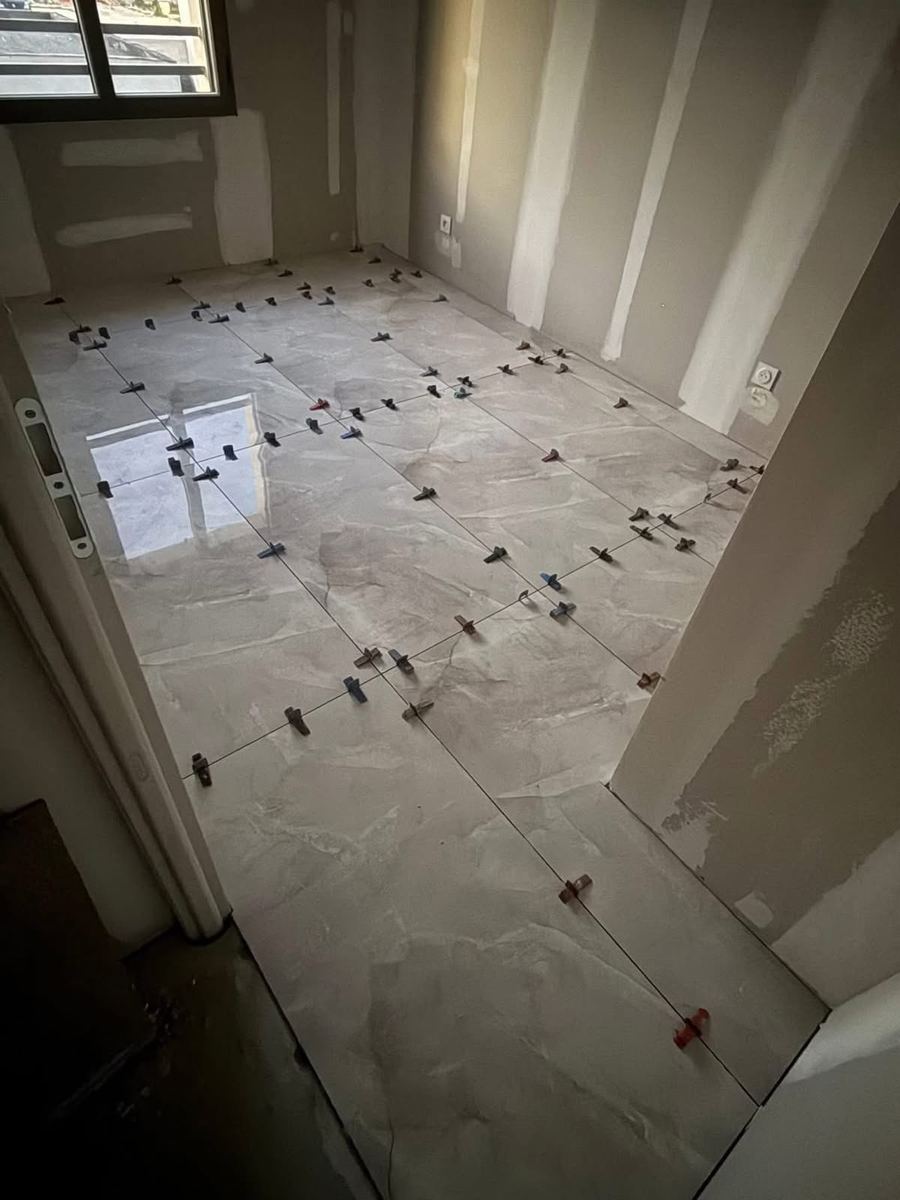 Pose d'un carrelage grand format en couloir, joints alignés au cordeau — Carrelage et faïence (En cours) | GLOBAL CONSTRUCTION