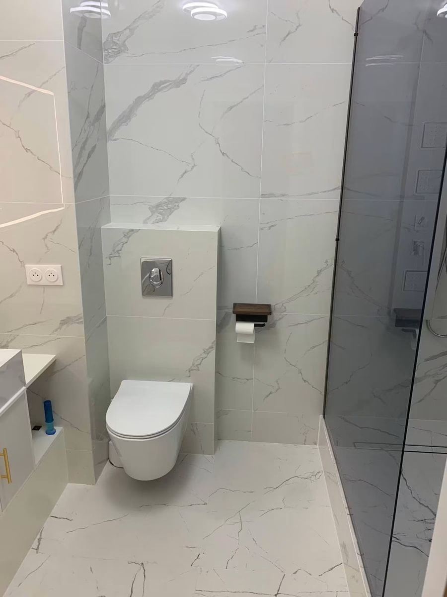 La même salle d'eau livrée : WC suspendu au même emplacement, douche et niche de rangement