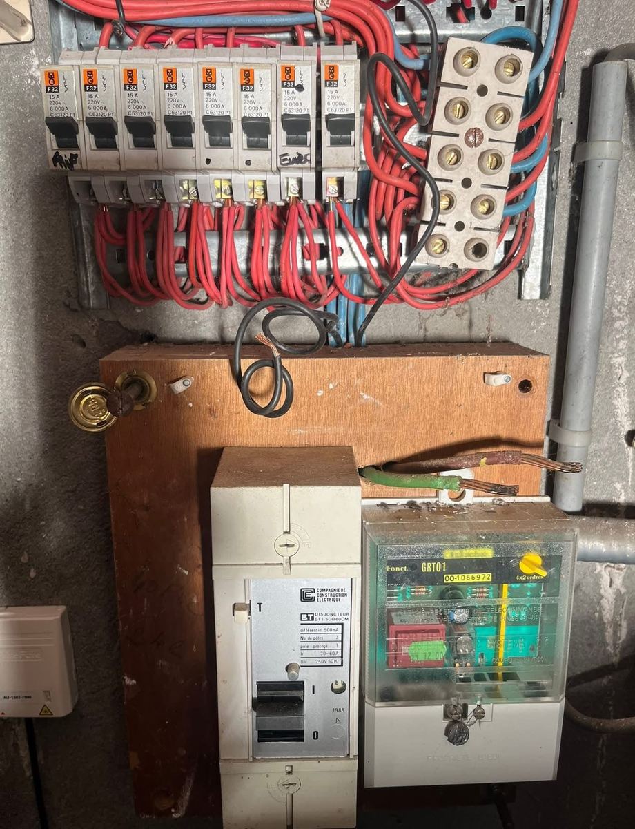 Tableau vétuste sur planche bois, à côté d'un compteur d'origine — Installation électrique (Avant) | GLOBAL CONSTRUCTION