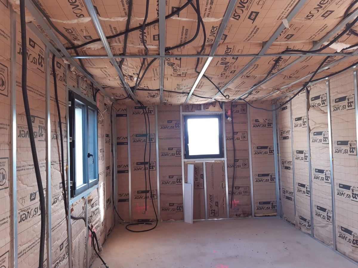 Pièce entièrement isolée : laine posée entre montants et sous plafond — Isolation et plâtrerie (En cours) | GLOBAL CONSTRUCTION
