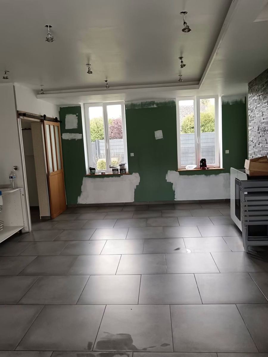 Mise en peinture d'un séjour : première passe sur les murs verts — Peinture et finitions (En cours) | GLOBAL CONSTRUCTION