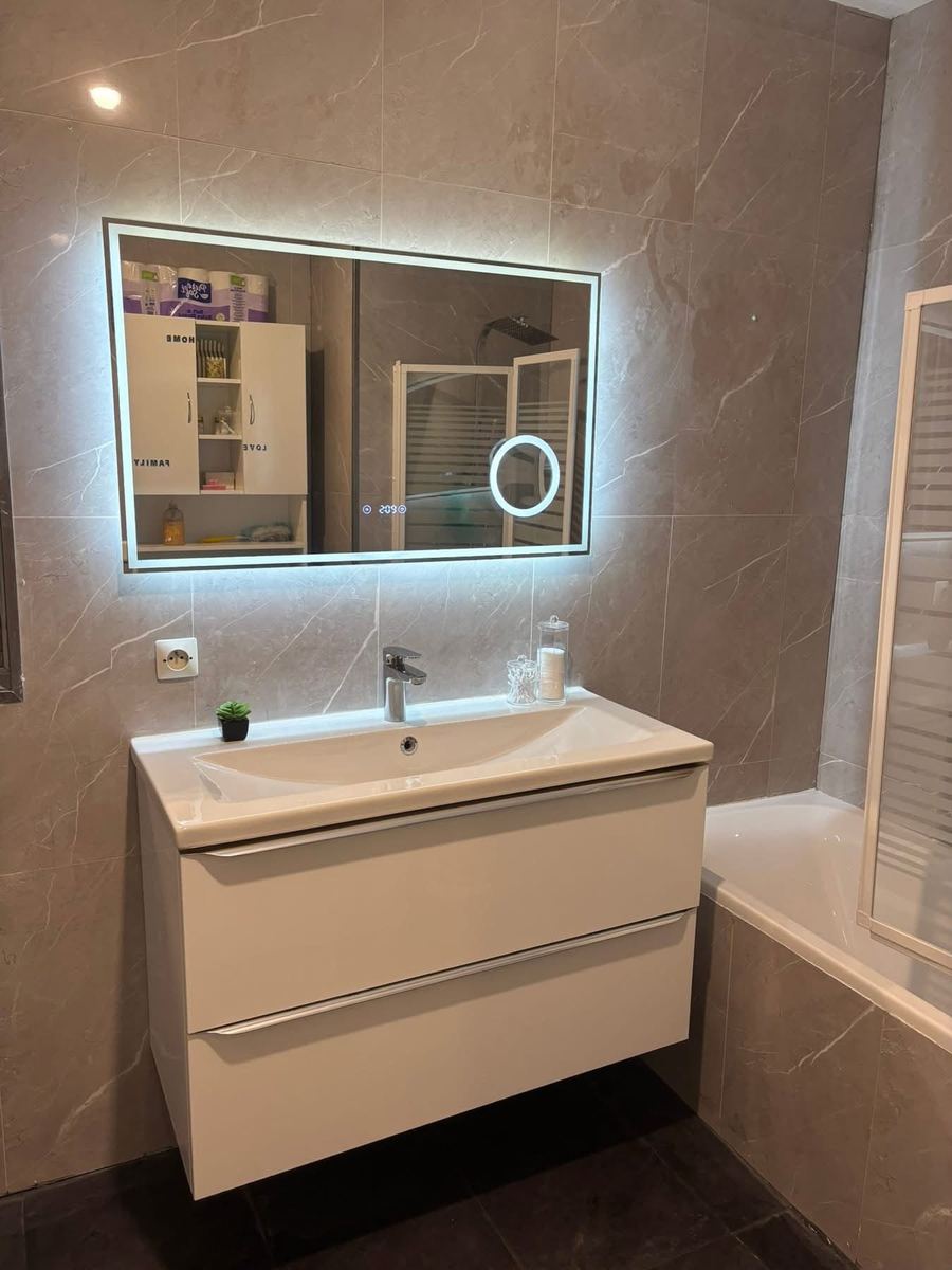 La même salle de bain livrée : meuble vasque, miroir rétroéclairé et baignoire neuve