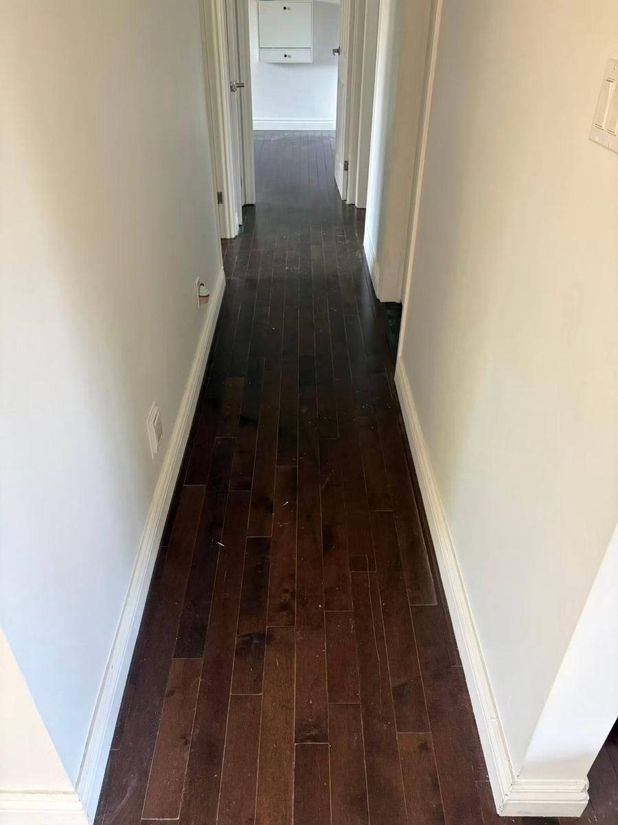 Couloir en parquet foncé terminé et protégé — Pose de parquet et sols (Fin de chantier) | GLOBAL CONSTRUCTION